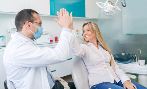 dentiste tapant dans la main d'un patient